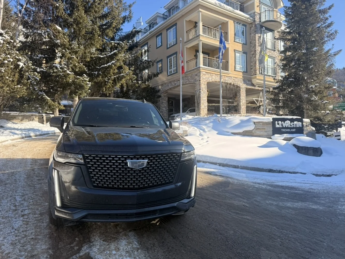 Cadillac Escalade at Le Westin Tremblant with the hotel sign and winter snow.